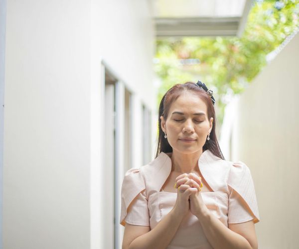 Person meditating outdoors with a serene natural background.
